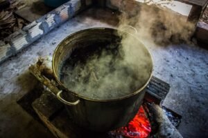DMT è legale: un bricco di ayahuasca, un tè contenente DMT, preparato su un fuoco aperto
